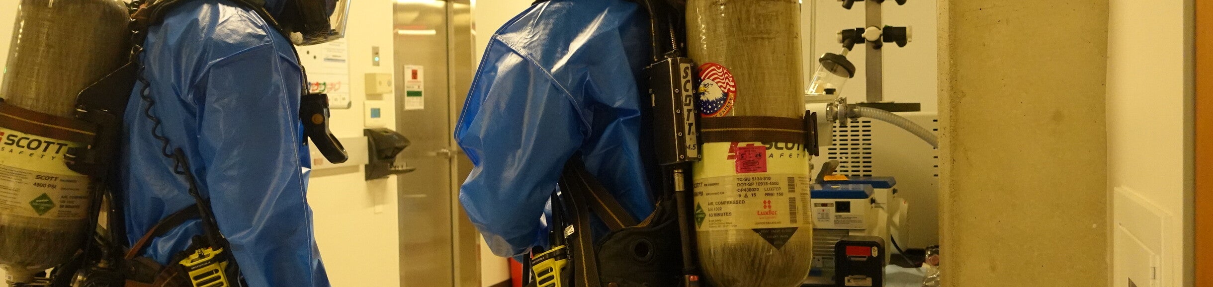 Two people in blue HAZMAT suites 