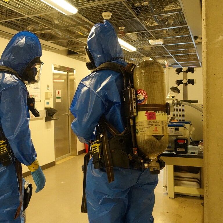 Two people in blue HAZMAT suites 