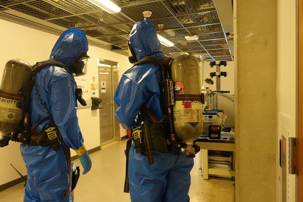 Two people in blue HAZMAT suites 